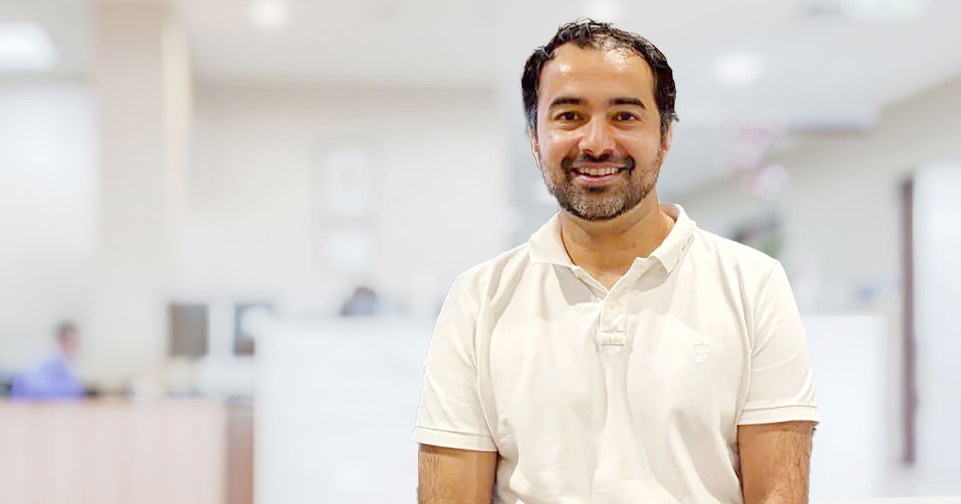Smiling doctor man standing straight in clinic